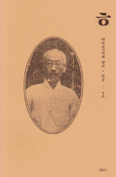Front cover of Hiut magazine, has a light brown background with a greyscale photo of a Korean man in a portrait oval shape