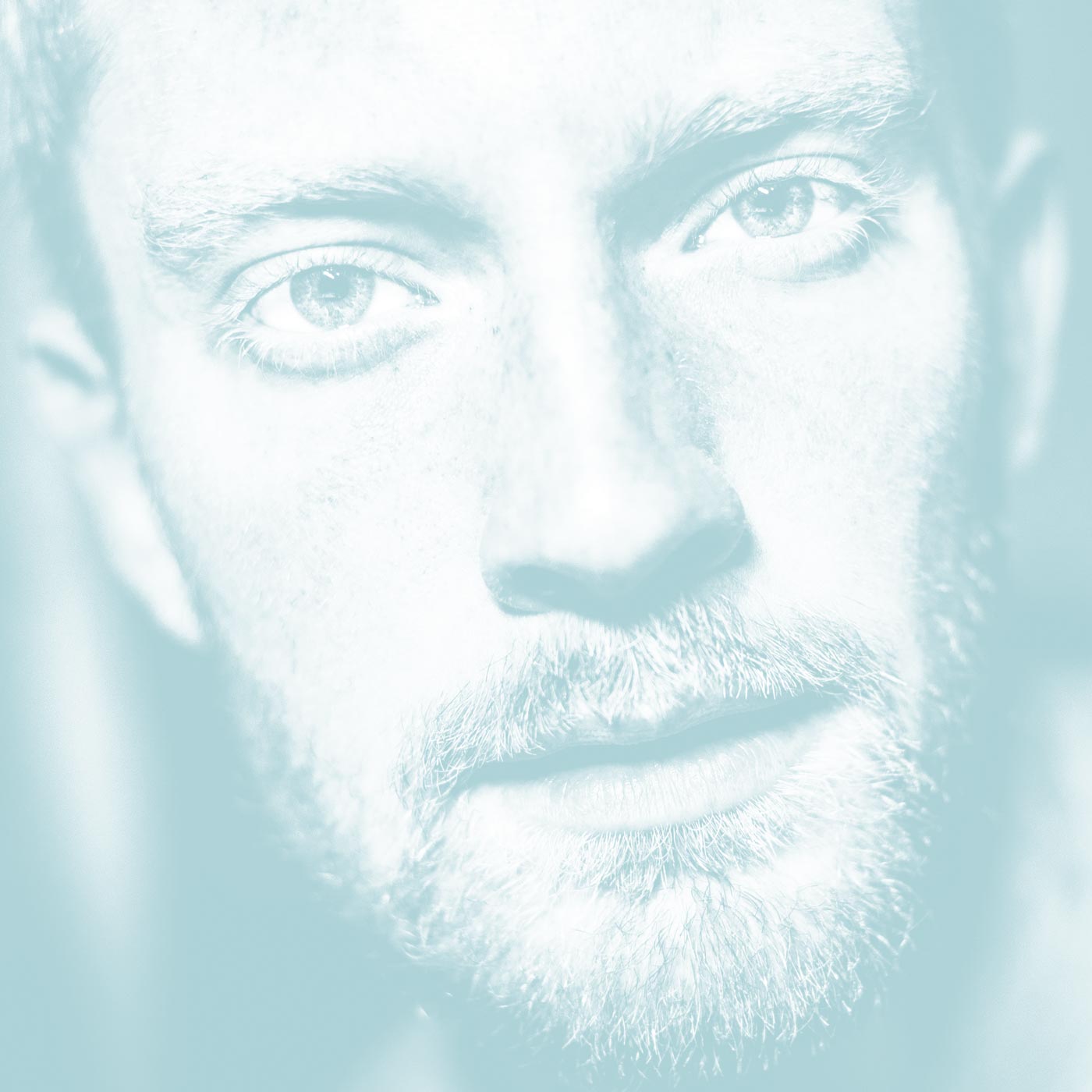 Photograph of a man's face with very light colour tone and depth, with a slight faded red colour