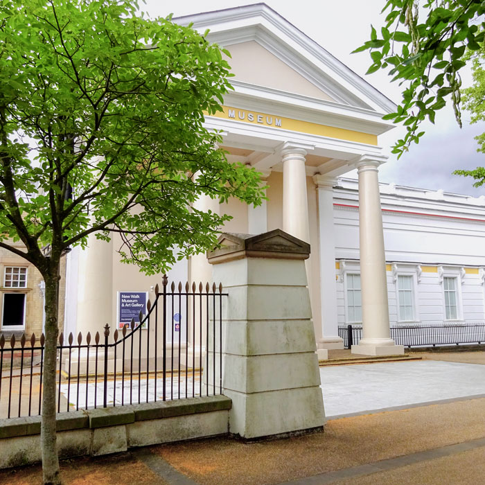 The front of New Walk Museum and Art Gallery, shows a large building with a 4-column architectural design and the front entrance
